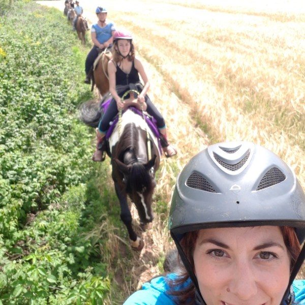 a person wearing a helmet is riding a horse