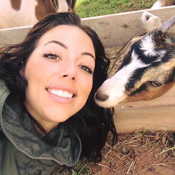 a woman standing next to a cow