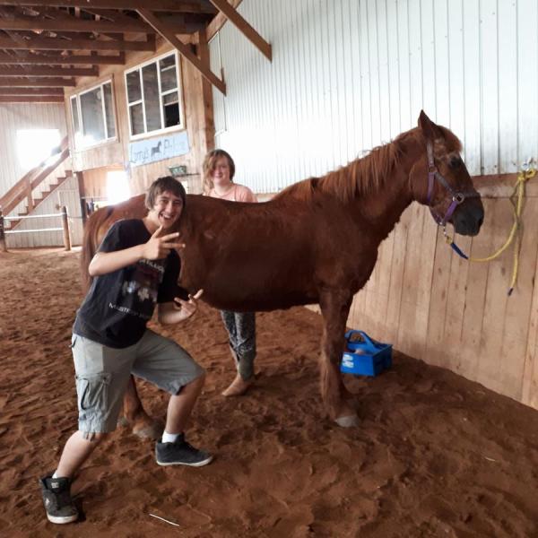 a person standing next to a horse in front of a building