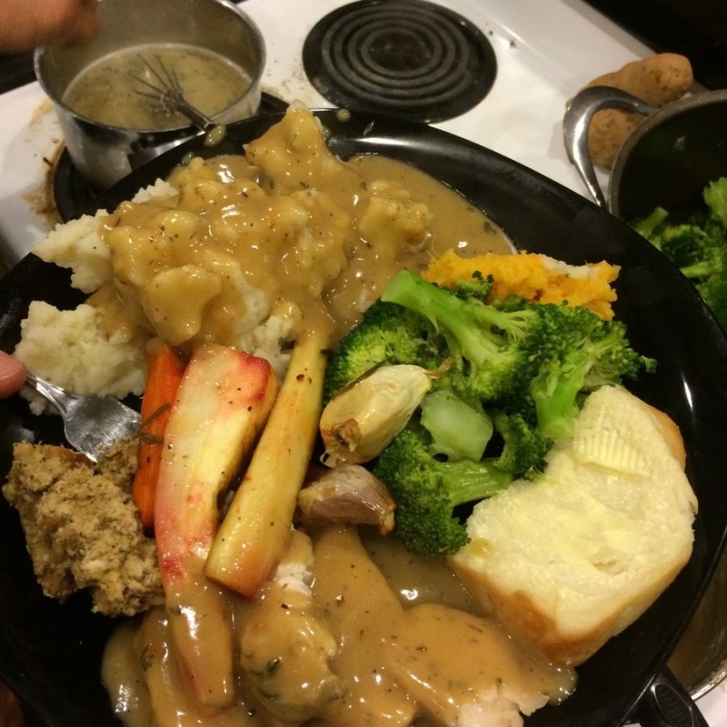 a pan filled with meat and vegetables cooking on a stove