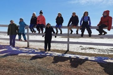 a group of people standing on top of a sandy beach