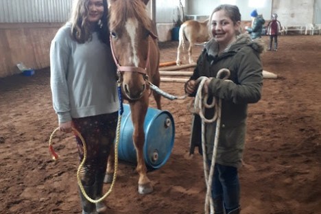 a group of people standing next to a horse